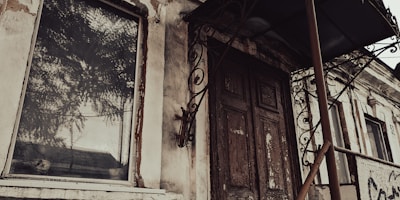 The eerie glow of a ruined building’s fire reflecting off a rusty metal door.