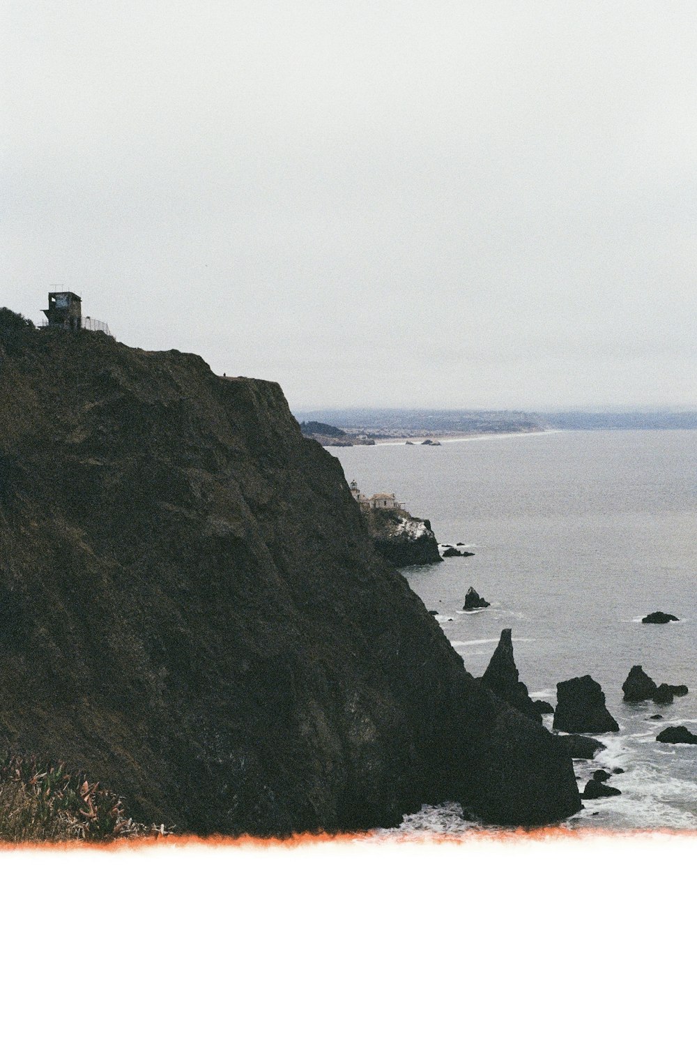 a rocky cliff with a lighthouse on it