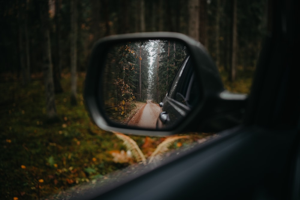 a side view mirror showing a person in a car