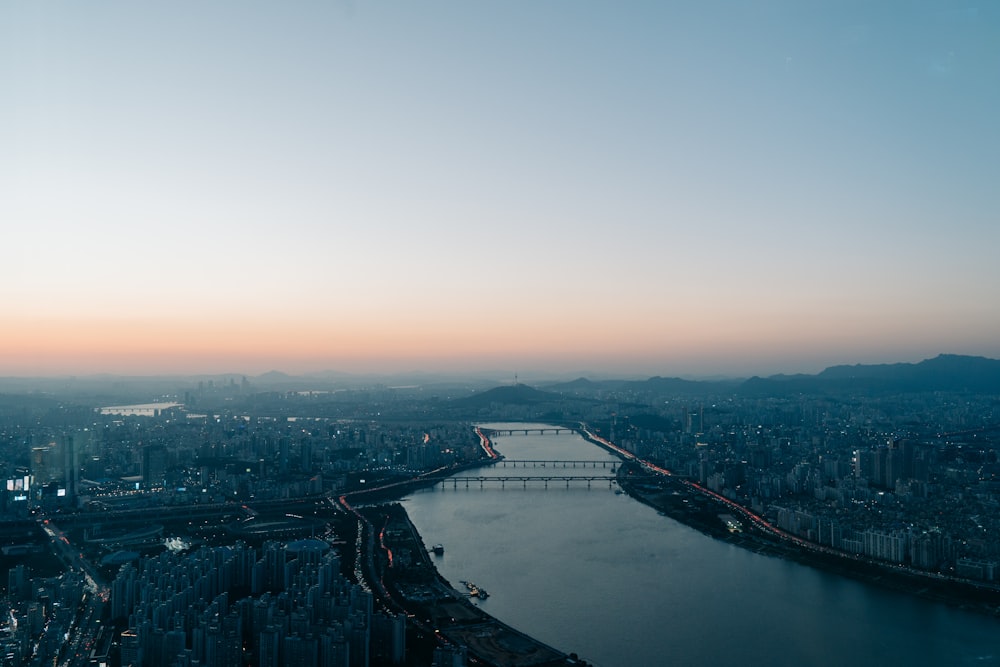 a bridge over a river with a city in the background