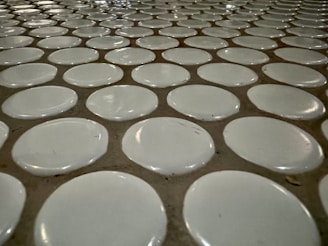 Close-up of hands laying ceramic tiles with precise alignment in a modern kitchen.