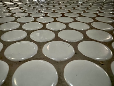 A professional tiler carefully placing tiles on a floor.