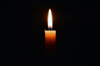 a lit candle in the dark