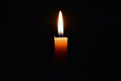 a lit candle in the dark
