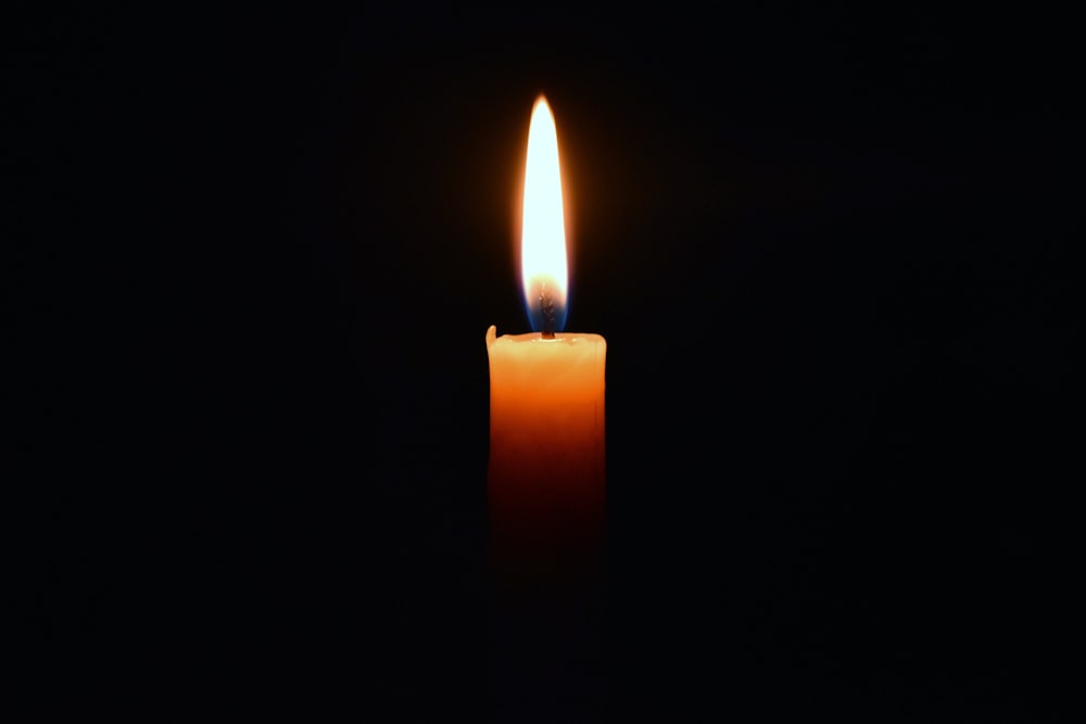 a lit candle in the dark