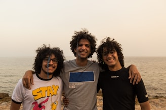 a group of men posing for a picture on a beach