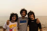 a group of men posing for a picture on a beach