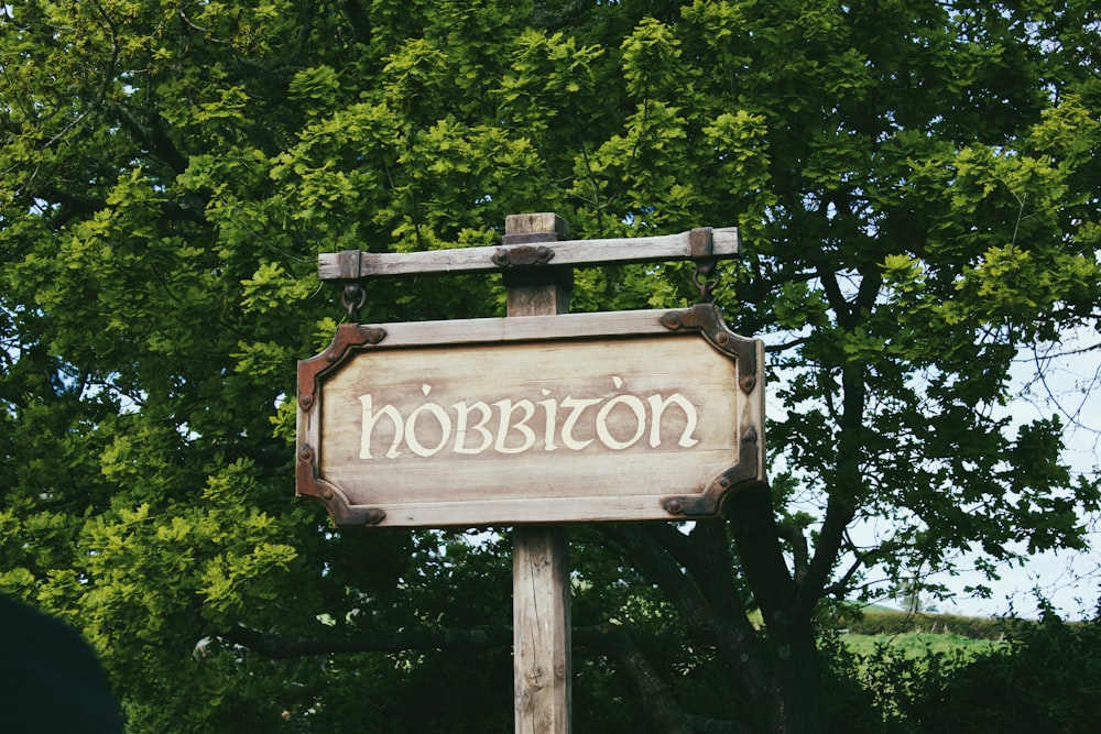 a sign board is posted on a wooden post