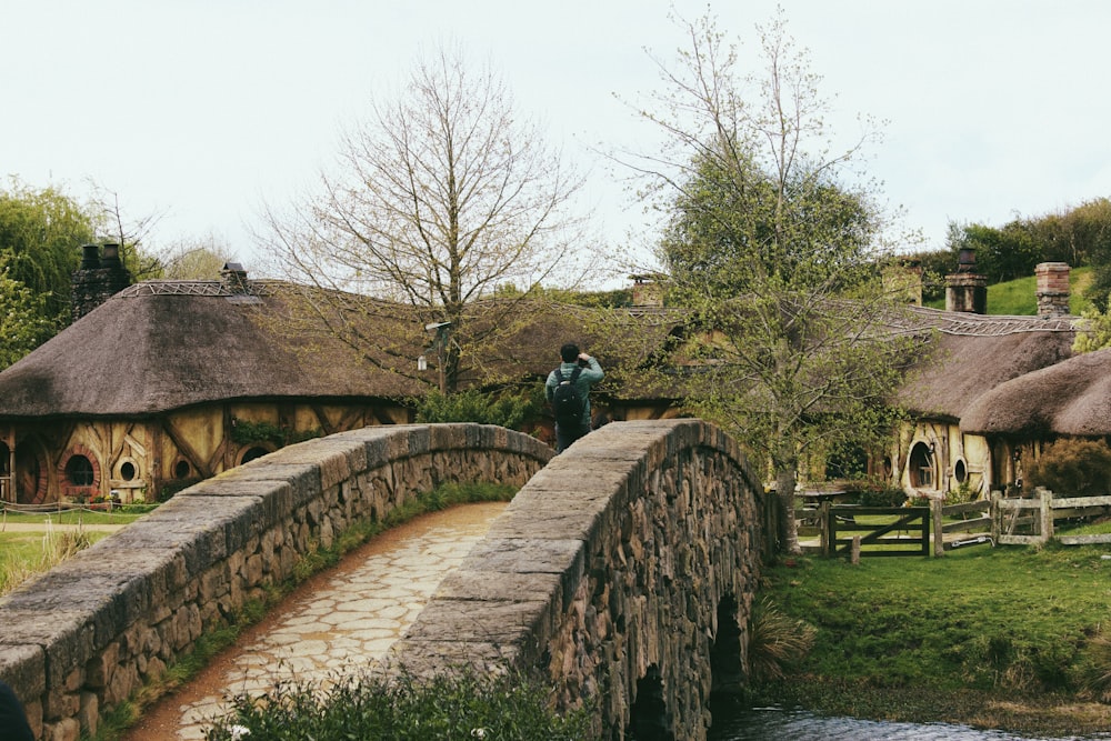 a person standing on a stone bridge