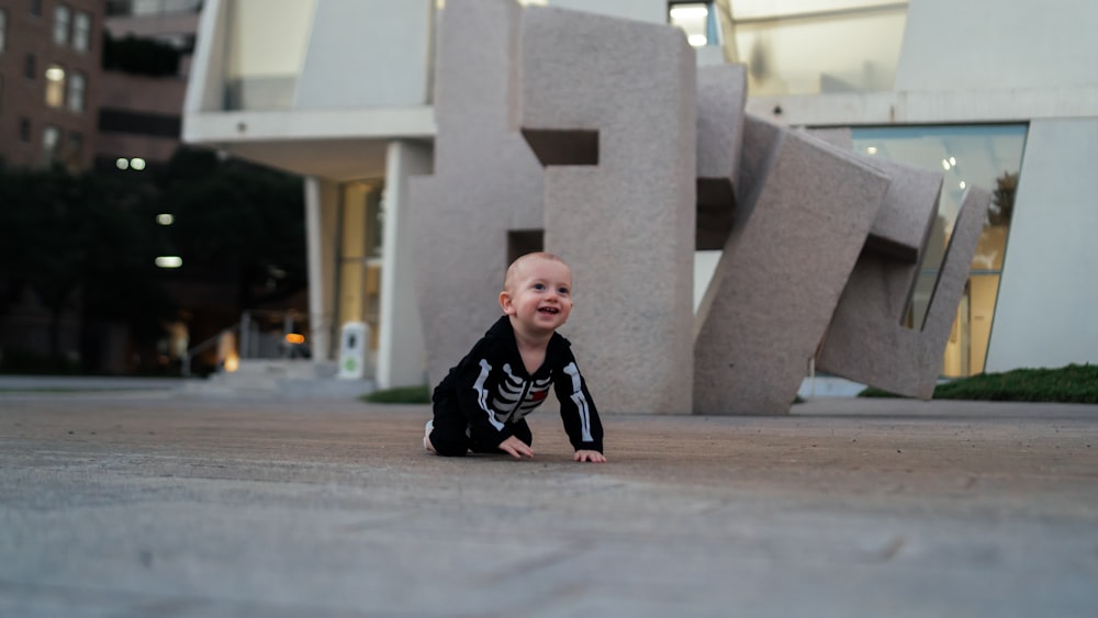 a baby crawling on a concrete surface