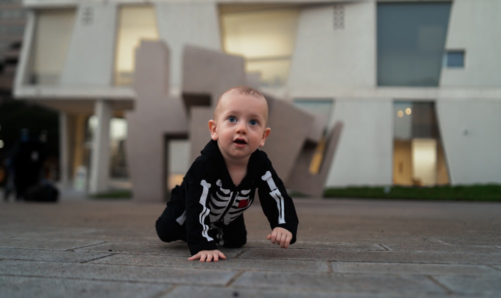 a baby crawling on a wood surface