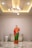a person in a robe standing in a room with a white wall and lights
