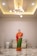 a person in a robe standing in a room with a white wall and lights