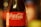 A close-up view of a Coca-Cola bottle with a red label and white text reading 'Coca-Cola Sabor Original'. The bottle is glass and the focus is on the label, with a blurred background.
