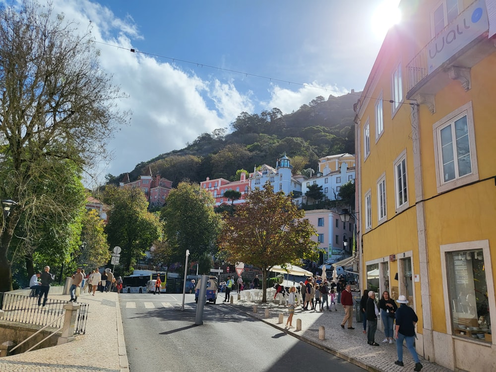 Eine Gruppe von Menschen, die auf einer Straße mit Gebäuden und Bäumen spazieren gehen