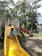 A joyful child climbing colorful playground equipment under supervision.