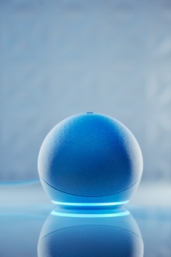 A sleek smart speaker with glowing cyan accents.