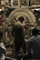 A group of artisans gathered around a fire, crafting mandars late into the evening