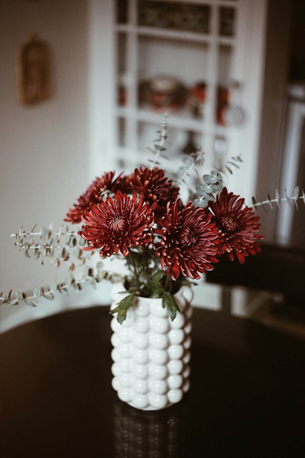 a vase with red flowers