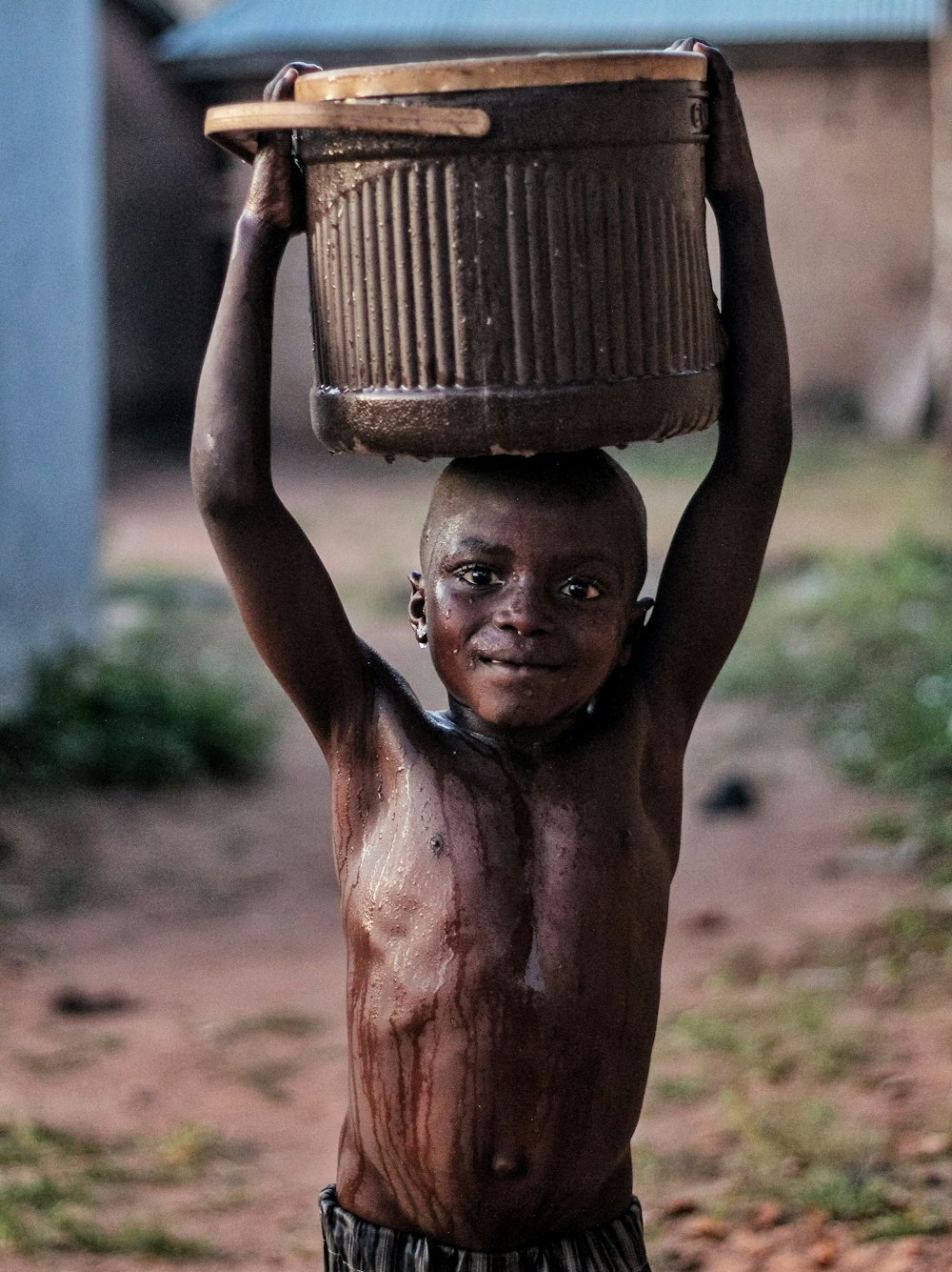 a boy carrying a basket on his head