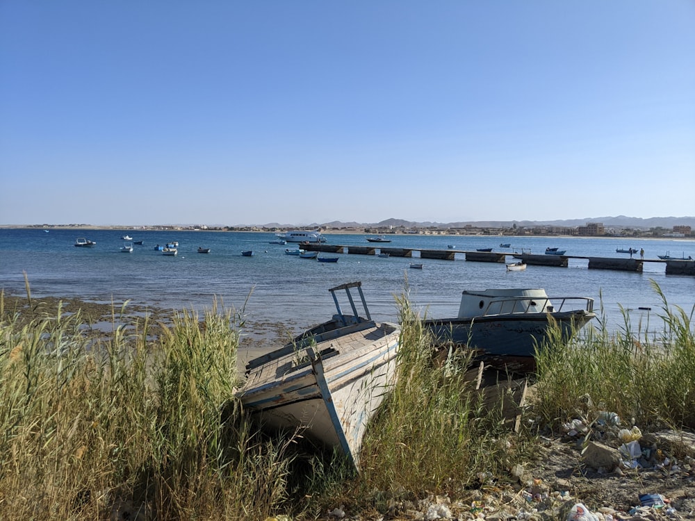 a boat sits on the shore of a lake