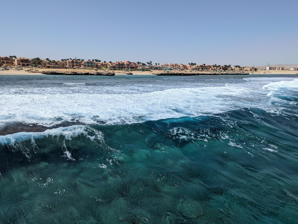 waves crashing on a beach with Bondi Beach in the background