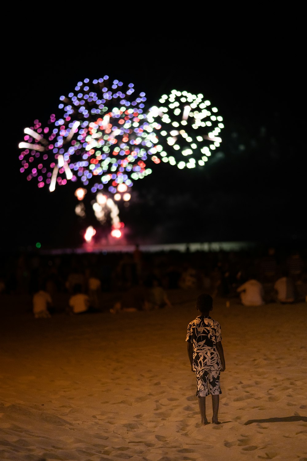 uma pessoa em pé na frente de uma grande exibição de fogos de artifício