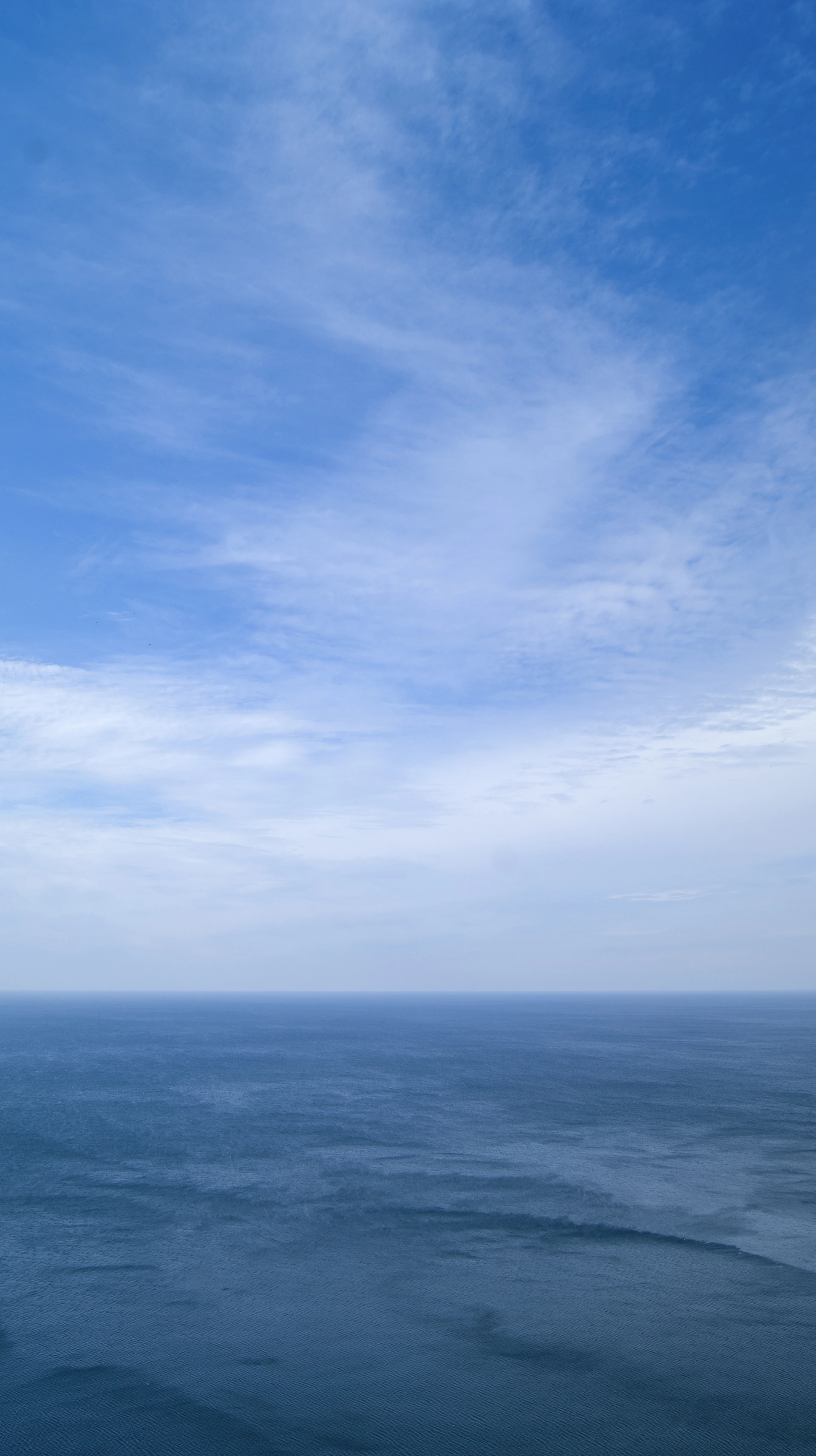 a body of water with a blue sky above it