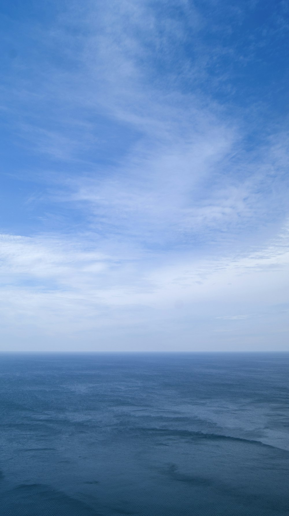 a body of water with a blue sky above it