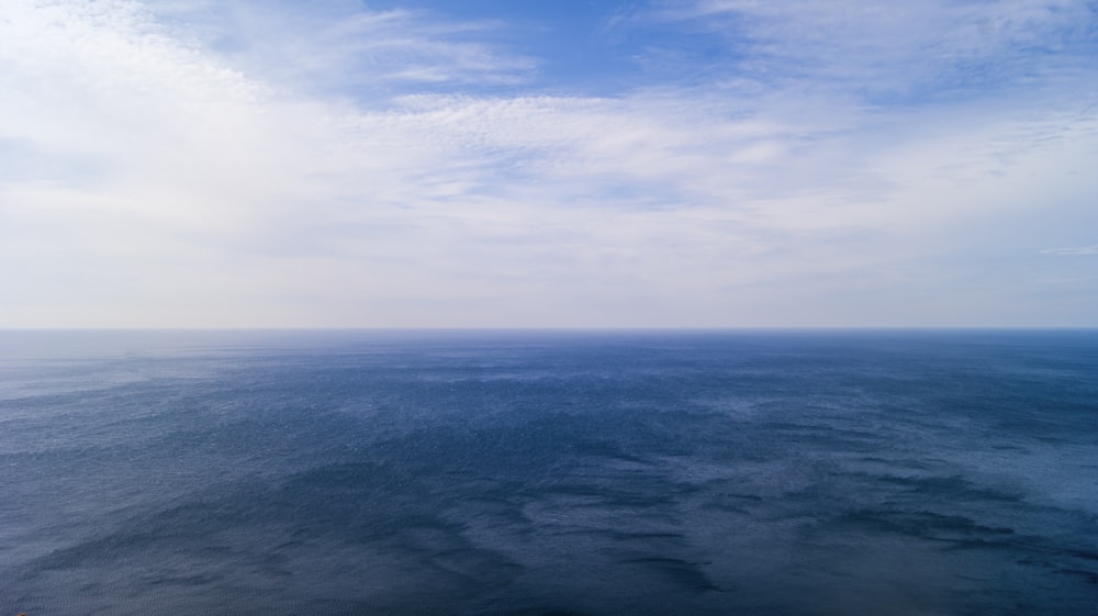 a body of water with clouds above it