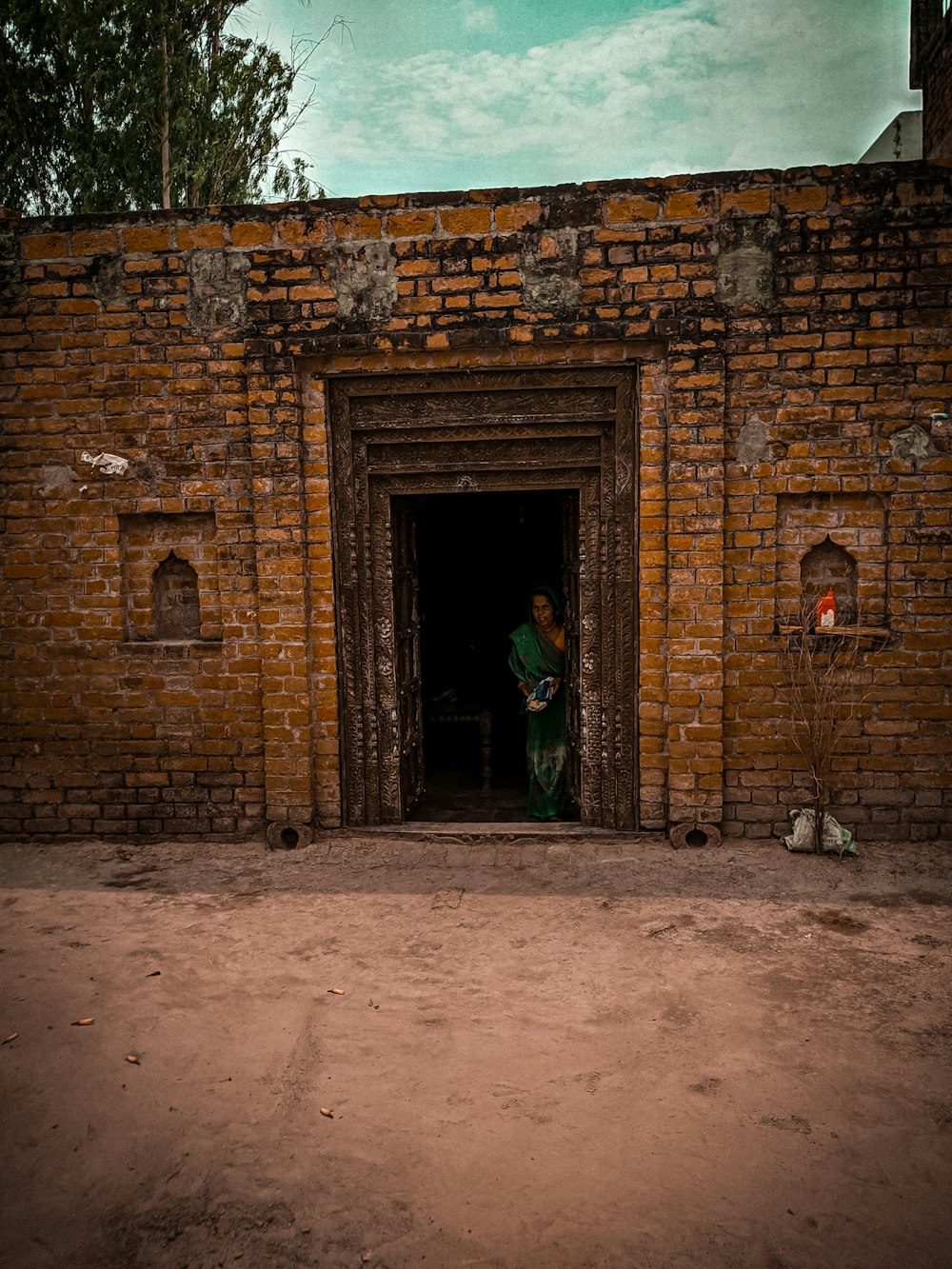 a person standing in a doorway of a brick building