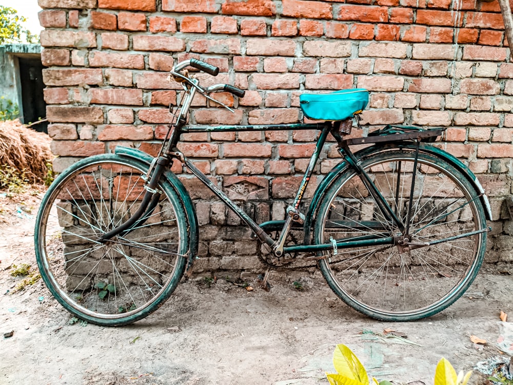 a bicycle parked in front of a brick wall