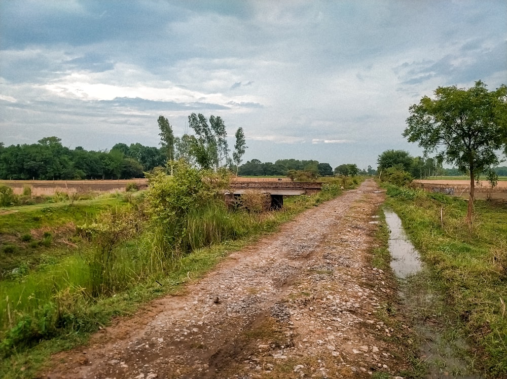 a dirt road with a bridge over it