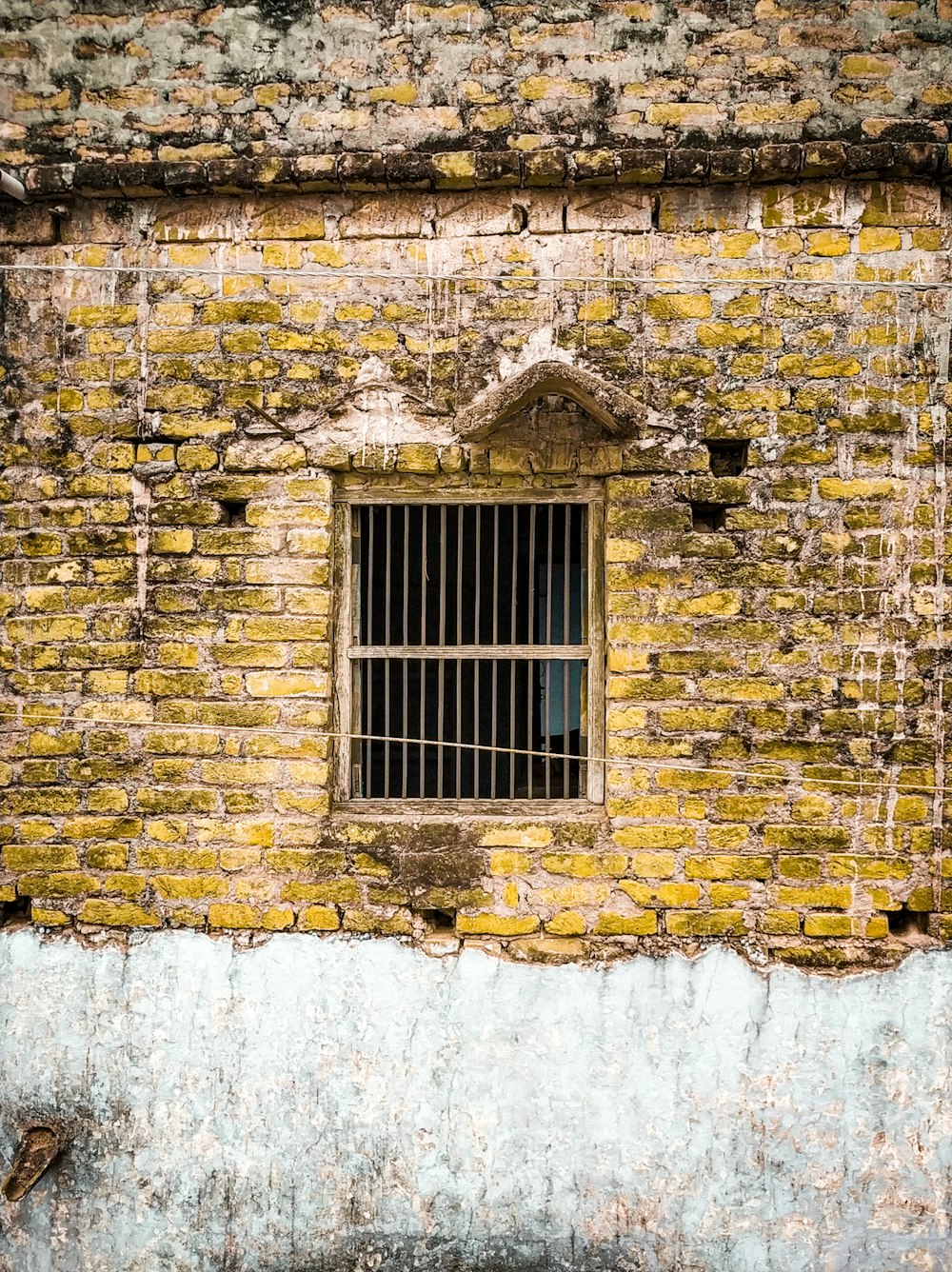 a window in a brick building with Kaaba in the background