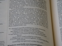 A close-up of an open book with text in a serif font on off-white pages. The content appears to be prose with numbered sections at the beginning of each paragraph. The paper shows some wear, giving it a slightly aged appearance.