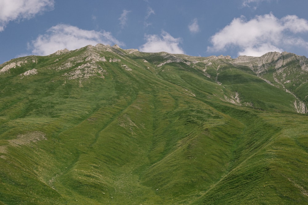 a grassy mountain with a valley below