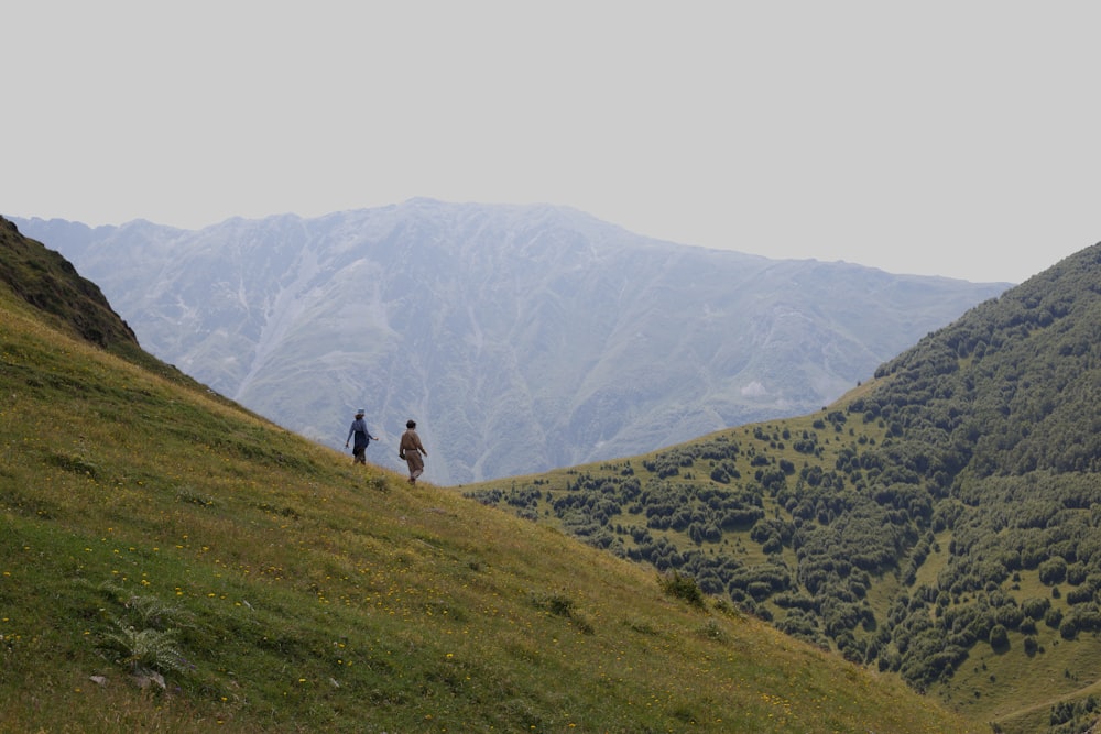 a group of people walking on a hill