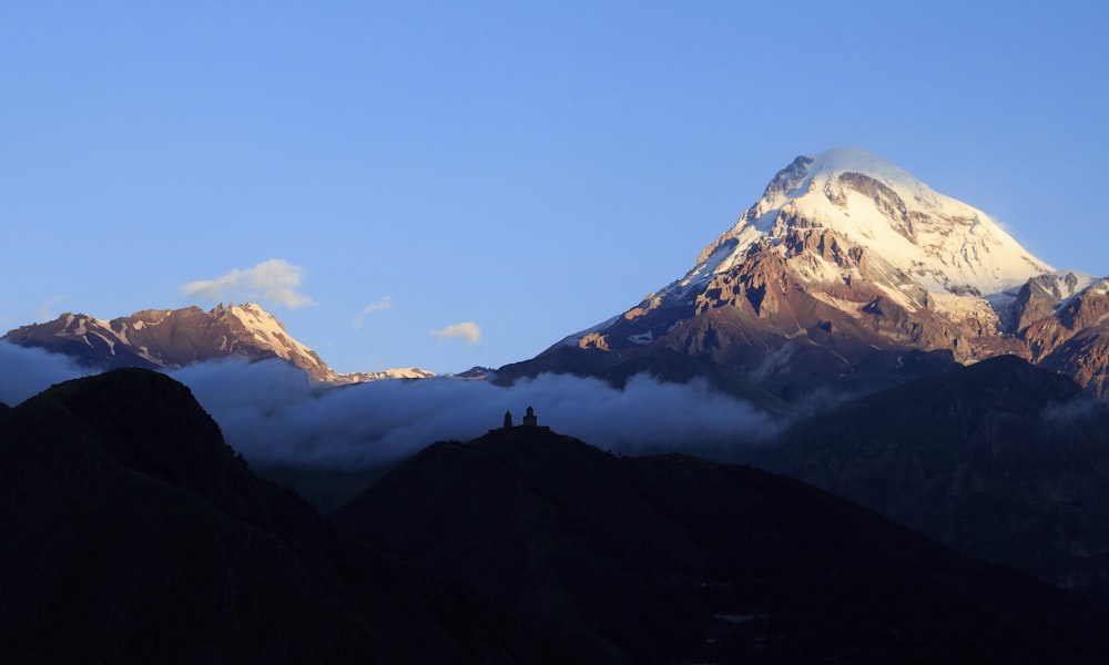 a mountain range with clouds below