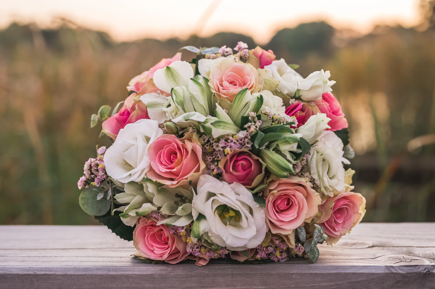 How to DIY your own wedding bouquet — A bride holding a beautifully arranged, classic round bouquet.