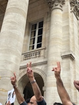 A group of diverse Americans holding hands in front of a historic courthouse.