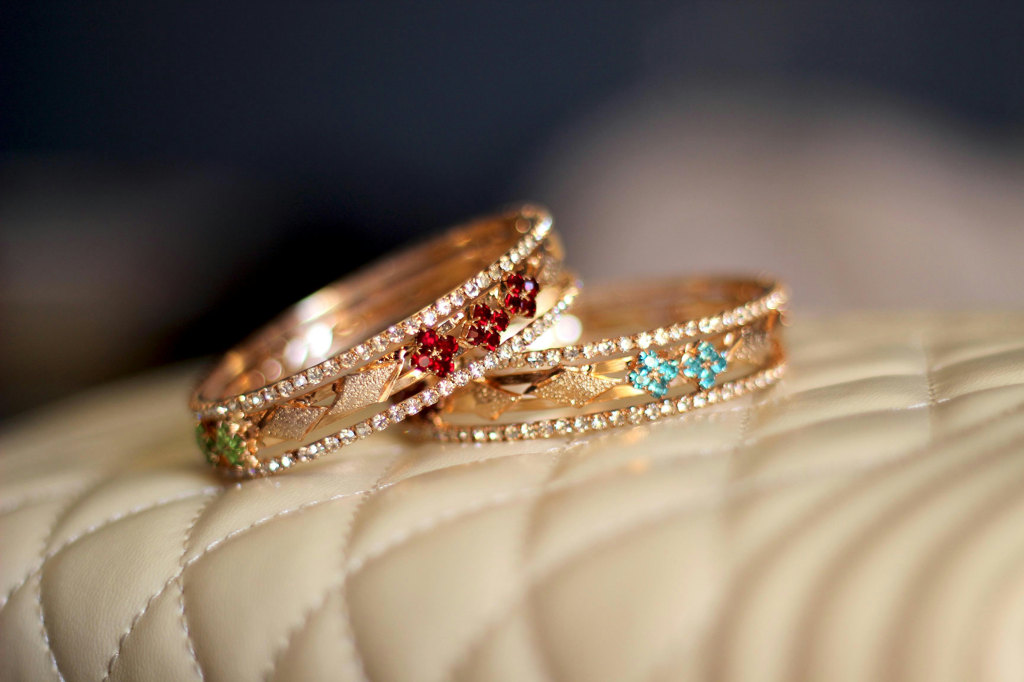 Colorful enamel work bangles with floral motifs on marble surface