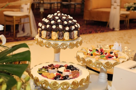 A beautifully decorated event table with elegant cakes and pastries.