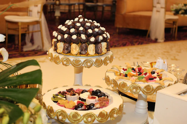Close-up of a beautifully arranged dessert table featuring rich red and cream tones with delicate sparkles.