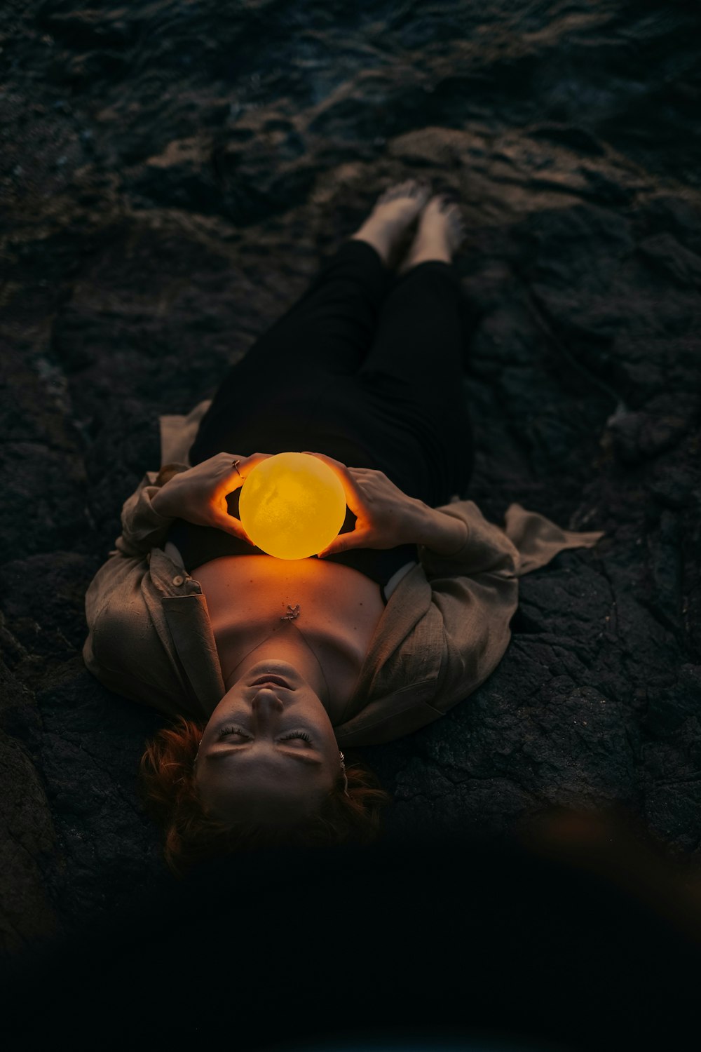 a person lying on the ground with a bottle of orange juice
