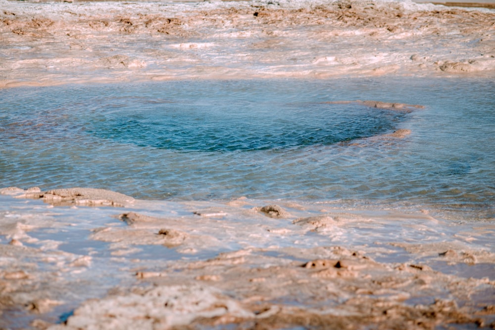 a body of water with rocks and sand