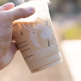 a hand holding a white box with a logo on it