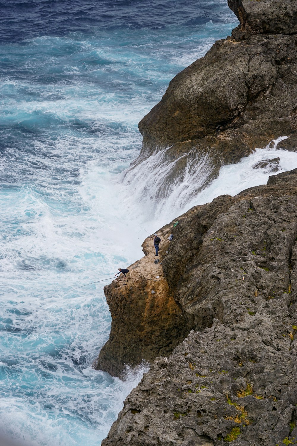 people climbing a cliff