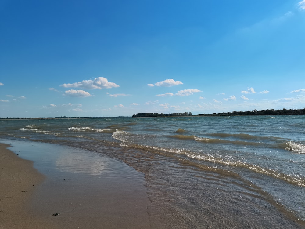 uma praia com ondas e um céu azul