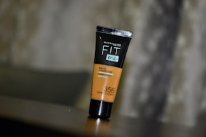 Close-up of a rich, creamy foundation bottle with a smooth swatch on skin.