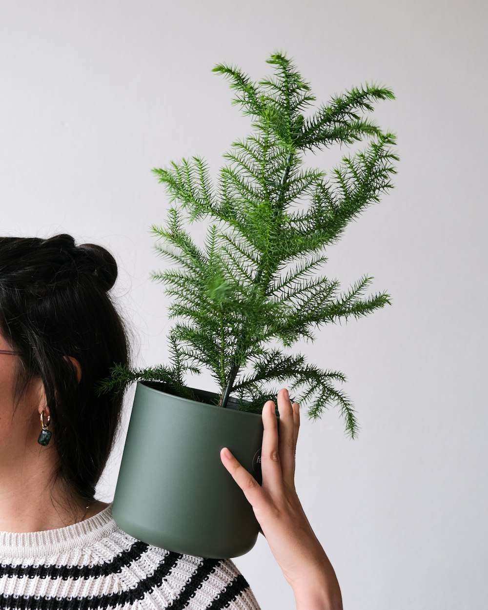 a woman holding a green plant